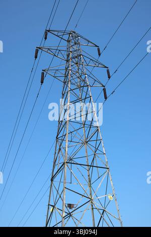 Tralicci di energia elettrica contro il cielo blu Foto Stock