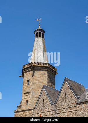 Campanile in pietra di Fougères in Bretagna, costruito nel 1397, visto in una giornata di sole con cielo blu, che si innalza sopra i tetti di ardesia di edifici medievali storici. Foto Stock