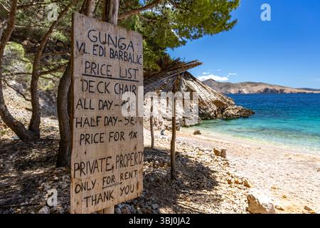 Un listino prezzi per noleggiare un lettino e un ombrellone sulla spiaggia dell'isola DI KRK sulla spiaggia di Jablanova Foto Stock