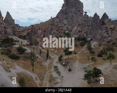 Una vista droni di Göreme in Cappadocia, che rivela case nelle grotte, camini delle fate e antichi paesaggi immersi in luce soffusa e ricchi toni terrosi. Foto Stock