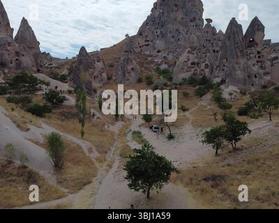 Una vista droni di Göreme in Cappadocia, che rivela case nelle grotte, camini delle fate e antichi paesaggi immersi in luce soffusa e ricchi toni terrosi. Foto Stock