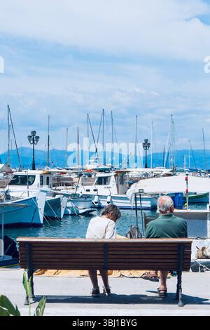 Tranquillo tramonto nel porto con coppie anziane in relax Foto Stock