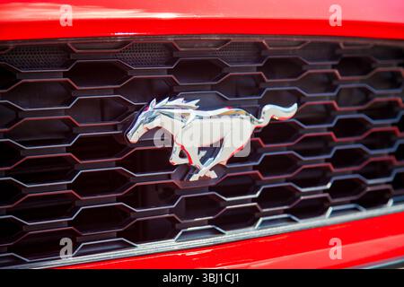Vilnius, Lituania - 31-05-2025 - Logo Ford Mustang a forma di cavallo d'argento sulla griglia frontale di un'auto rossa Foto Stock