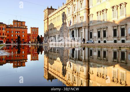 Riflesso dello storico Palazzo Ducale di Modena e della statua di Ciro Menotti in Piazza Roma coperta dall'acqua, catturando la grandezza dell'Italia Foto Stock
