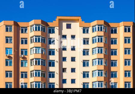 Nuovo edificio ad appartamenti a più piani, con vista dal basso su un cielo blu. Foto Stock