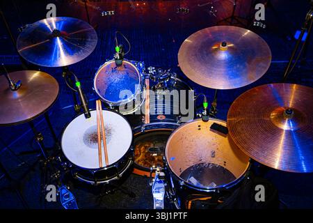 Vista dall'alto di un set di tamburi sul palco con illuminazione blu e rossa Foto Stock