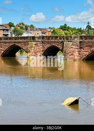 Vista del fiume Dee a Chester con il ponte in mattoni rossi per Handbridge, una piccola barca a grandezza naturale e il cielo blu in una giornata di sole Foto Stock