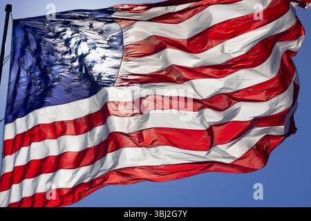 Spettacolare bandiera americana retroilluminata che ondeggia nel vento. Foto Stock