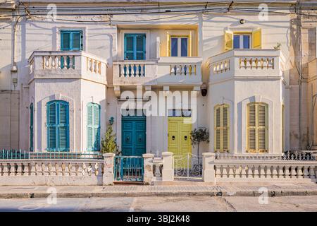Splendida vista di una tipica casa maltese con porte colorate e persiane a San Giuliano (San Ġiljan), Malta Foto Stock