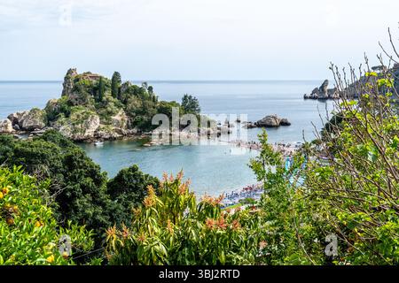 Taormina, Sizilien - Italia - 05-04-2025: La vista dell'Isola bella dall'alto mostra l'isola lussureggiante, il mare cristallino, la costa rocciosa e la spiaggia affollata di Taormina, Foto Stock