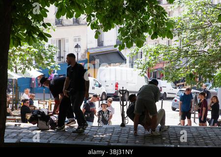 Parigi, Francia. 12 giugno 2025. Tre uomini chiacchierano in piazza Emile Goudeau, Montmartre, poi pochi istanti dopo vengono attaccati a terra e ammanettati da poliziotti che li sospettano di essere ladri. I turisti a Parigi sono spesso avvertiti di essere in guardia per i borseggiatori nelle zone turistiche più affollate. Crediti: Anna Watson/Alamy Live News Foto Stock