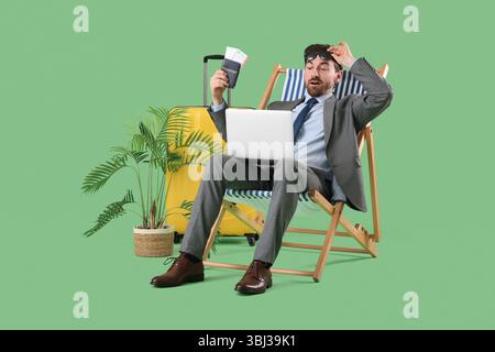 Uomo d'affari scioccato con passaporto e computer portatile su una sedia a sdraio su sfondo verde. Concetto di vacanza estiva Foto Stock