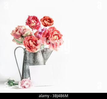 Bouquet di peonie rosa in caraffa con biglietto di auguri su sfondo bianco. Festeggiamo con un bel mazzo di fiori. Vista frontale con spazio di copia. Foto Stock