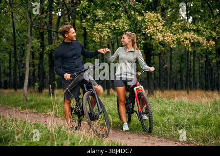 Una coppia felice e felice condivide un delizioso momento romantico mentre si pedala insieme lungo un bellissimo sentiero panoramico circondato da vib Foto Stock
