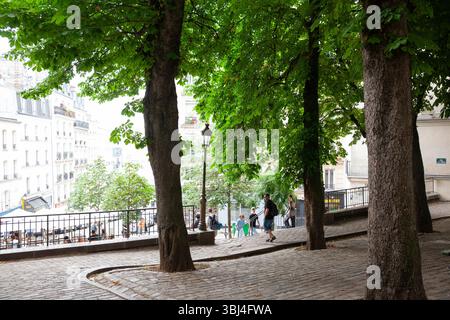 Meteo, Francia. 12 giugno 2025. Mentre Parigi sperimenta un'ondata di caldo, Place Emile Goudeau a Montmartre offre un luogo fresco e ombreggiato per i turisti di passaggio. La piazza una volta ospitava Pablo Picasso. Si prevede che le temperature raggiungano i 32 centigradi prima di raffreddarsi leggermente con temporali durante il fine settimana. Crediti: Anna Watson/Alamy Live News Foto Stock