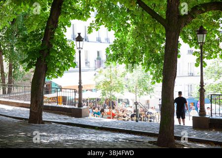 Meteo, Francia. 12 giugno 2025. Mentre Parigi sperimenta un'ondata di caldo, Place Emile Goudeau a Montmartre offre un luogo fresco e ombreggiato per i turisti di passaggio. La piazza una volta ospitava Pablo Picasso. Si prevede che le temperature raggiungano i 32 centigradi prima di raffreddarsi leggermente con temporali durante il fine settimana. Crediti: Anna Watson/Alamy Live News Foto Stock