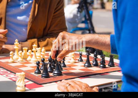 Due persone che giocano a scacchi all'aperto il giorno della domenica in un'area pubblica Foto Stock