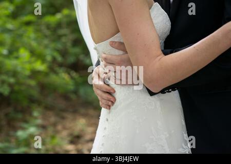 Sposa e sposo si abbracciano nell'intimo momento del matrimonio Foto Stock