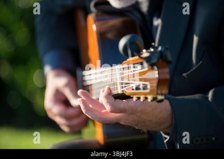 Primo piano del chitarrista che suona la chitarra acustica classica all'aperto Foto Stock