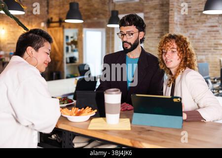 Colleghi che collaborano durante le pause in un ufficio moderno Foto Stock