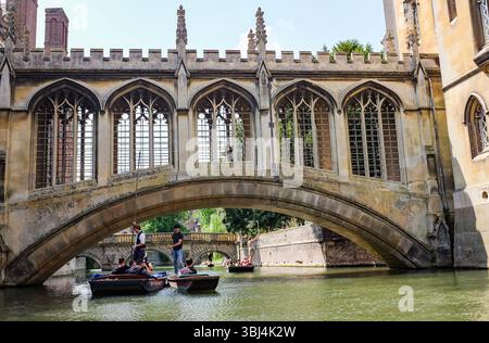 Cambridge Regno Unito 11 giugno 2025 - i turisti si godono un viaggio di punting passando sotto il famoso Ponte dei Sospiri lungo il fiume Cam a Cambridge in una calda giornata di sole nel Regno Unito: Credit Simon Dack Foto Stock