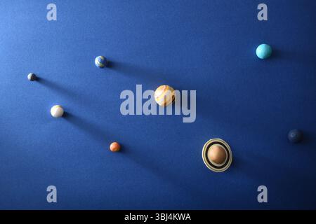 Concetto di sistema solare con pianeti su cartone blu testurizzato. Vista dall'alto. Foto Stock