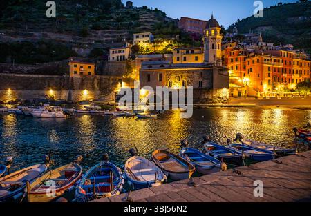 All'alba, il porto delle barche di Vernazza, Italia, si illumina di colori vivaci, incorniciato da splendidi edifici in stucco in questo iconico villaggio delle cinque Terre. Foto Stock