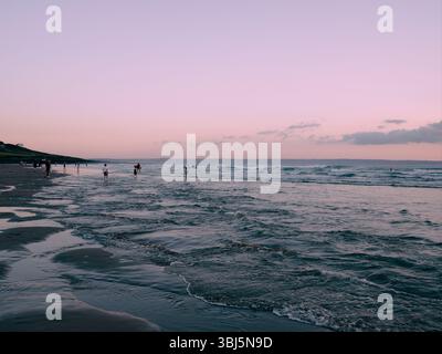 Persone che si godono il mare al crepuscolo Croyde Beach North Devon Inghilterra Regno Unito Foto Stock