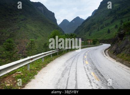 Strada tortuosa tra le ripide montagne dell'anello ha Giang nel nord del Vietnam Foto Stock
