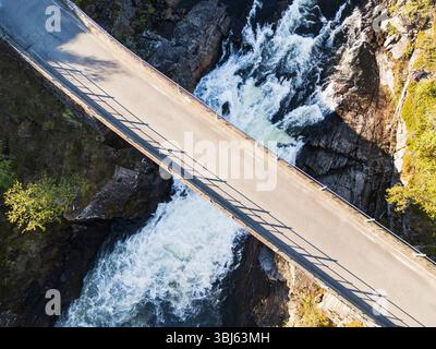 Vista mozzafiato dall'alto di un ponte in auto su un turbolento fiume di montagna in un canyon roccioso, un paesaggio estivo di natura selvaggia in Norvegia. Foto Stock