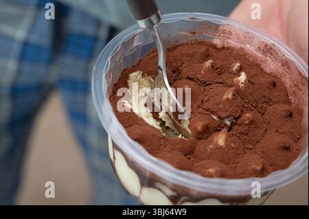 Concediti un delizioso dessert tiramisù splendidamente presentato in un contenitore trasparente Foto Stock