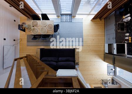Questa immagine mostra un'area soggiorno aperta splendidamente disposta, con un elegante tavolo da pranzo, comodi posti a sedere e un'atmosfera invitante illuminano Foto Stock