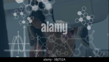 Donna reattiva che indossa giacca e visore VR in studio tecnologico, ologrammi molecolari, sovrapposizioni grafiche Foto Stock