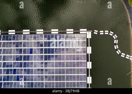 Impianto solare galleggiante con file di pannelli fotovoltaici montati sull'acqua, che produce energia elettrica rinnovabile senza inquinamento atmosferico. Concetto di eco Foto Stock