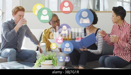 Quattro colleghi che esaminano documenti e cartelle blu sul divano, con tazze e icone mobili Foto Stock