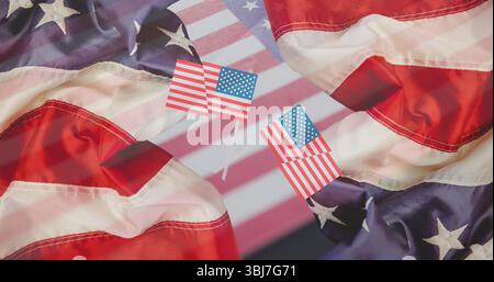 Visualizzazione di due bandiere americane in miniatura in piedi sul piano portapaziente, con sfondo a bandiera deformato Foto Stock