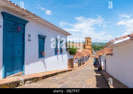 Barichara, Santander, Colombia, 11 ottobre 2024. Vista sopraelevata di una strada acciottolata a Barichara con colorate case coloniali sotto un blu luminoso Foto Stock