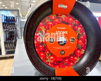 Alicante, Spagna - 11 giugno 2025: Padella antiaderente con vivace design a base di pomodori e funzioni a risparmio energetico esposte in un moderno negozio di utensili da cucina Foto Stock