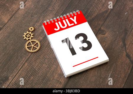 Calendario cubo bianco per luglio decorato con fiori margherita sopra sfondo blu con spazio per la copia Foto Stock