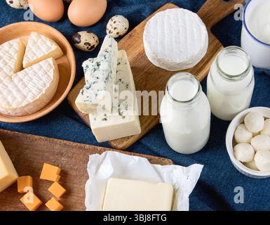 Diversi tipi di prodotti caseari: Formaggio, latte, burro, uova su sfondo grigio. Vista dall'alto. Foto Stock