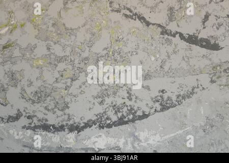 Pavimento levigato da uno studio d'arte che mostra sottili motivi astratti in grigio, bianco, giallo e nero. Le tracce di vernice stratificate creano un effetto visivo morbido Foto Stock