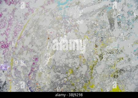 Pavimento in studio sabbiato che mostra un mix astratto di colori pastello come viola, blu, giallo e bianco. Gli strati di vernice formano una texture espressiva da sì Foto Stock