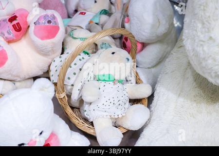Un grande cesto riempito fino all'orlo con vari adorabili animali farciti, tra cui un simpatico coniglio bianco Foto Stock