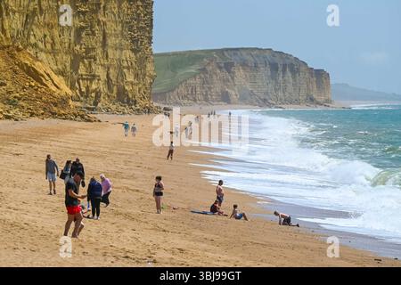 West Bay, Dorset, Regno Unito. 14 giugno 2025. Meteo nel Regno Unito. Gli amanti della spiaggia si godono il caldo sole estivo nella località balneare di West Bay nel Dorset. Crediti fotografici: Graham Hunt/Alamy Live News Foto Stock