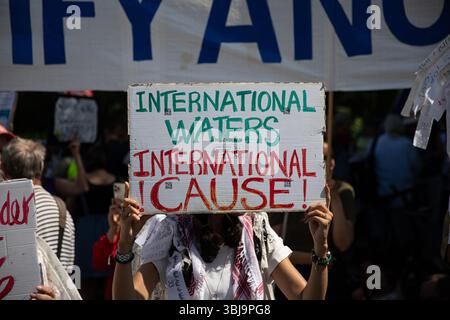 I manifestanti pro-palestinesi si sono riuniti sabato 14 giugno 2025, vicino all'iconica porta di Brandeburgo di Berlino, radunandosi lungo la Strasse des 17. Juni per denunciare le azioni militari di Israele a Gaza e opporsi alle spedizioni di armi tedesche in Israele. Sventolando bandiere palestinesi, iraniane e yemenite, i manifestanti hanno cantato slogan tra cui “dal fiume al mare, la Palestina sarà libera”, “c’è un solo Stato, la Palestina ‘48” e “mai più significa mai più per tutti”. Molti sostenevano segnali che accusavano Israele di genocidio e chiedevano di porre fine a quella che definivano la fame dei civili a Gaza. Alcuni manifestanti V Foto Stock