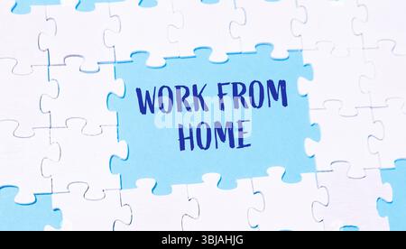 Puzzle con le parole Work from home scritte nel mezzo. Il puzzle è blu e bianco Foto Stock