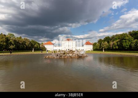 MONACO DI BAVIERA, GERMANIA - 17 MAGGIO 2025: Una pittoresca vista grandangolare dell'iconico Palazzo di Nymphenburg a Monaco di Baviera, Germania, vista attraverso il suo tranquillo palazzo lak Foto Stock