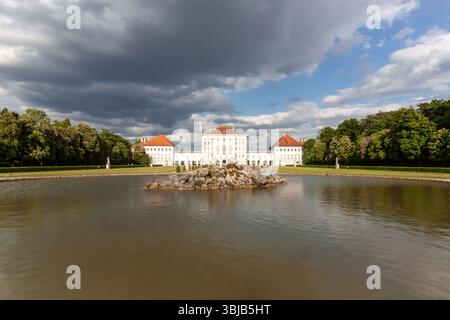 MONACO DI BAVIERA, GERMANIA - 17 MAGGIO 2025: Una pittoresca vista grandangolare dell'iconico Palazzo di Nymphenburg a Monaco di Baviera, Germania, vista attraverso il suo tranquillo palazzo lak Foto Stock