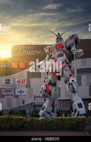 tokyo, odaiba - 22 maggio 2025: Vista del tramonto della gigante illuminata statua Unicorn Gundam creata da Hajime Katoki, di fronte al centro commerciale giapponese Foto Stock