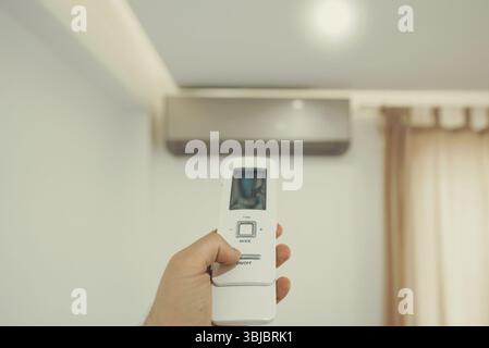 Tenere a mano il telecomando davanti all'impianto di climatizzazione Foto Stock